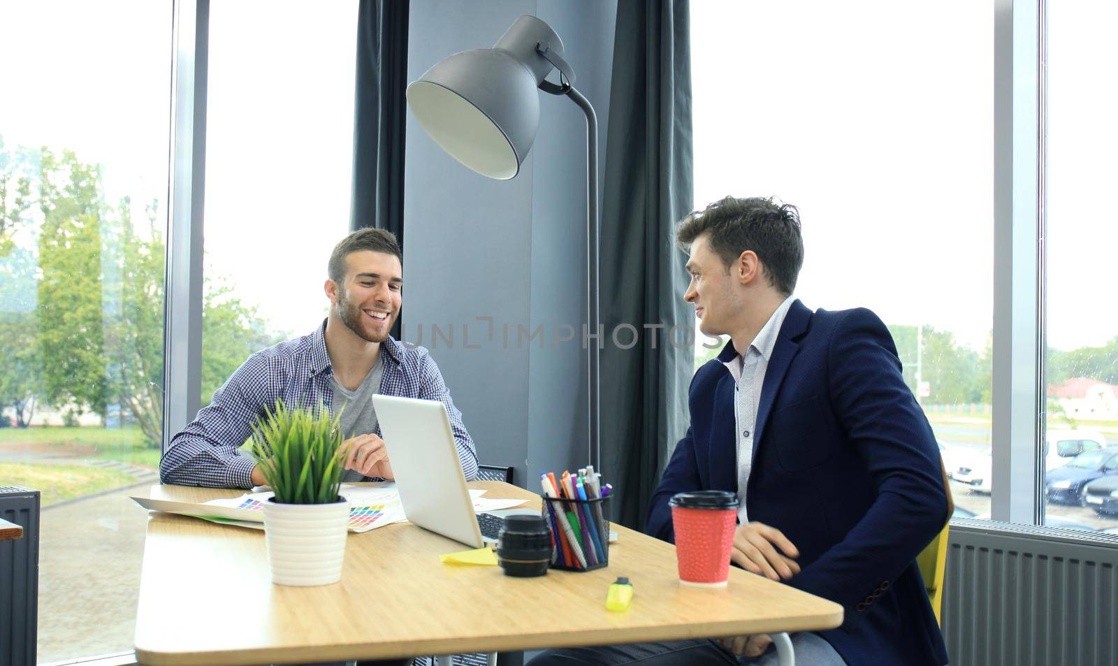 Two young modern men discussing work in the office studio. by tsyhun