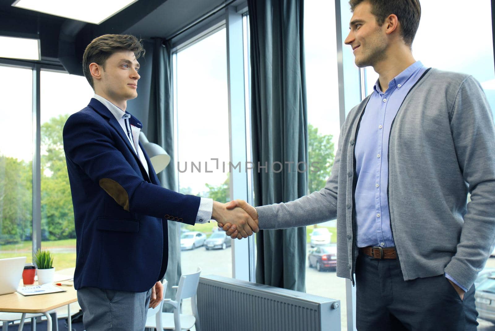 Business handshake. Two businessman shaking hands in the office.