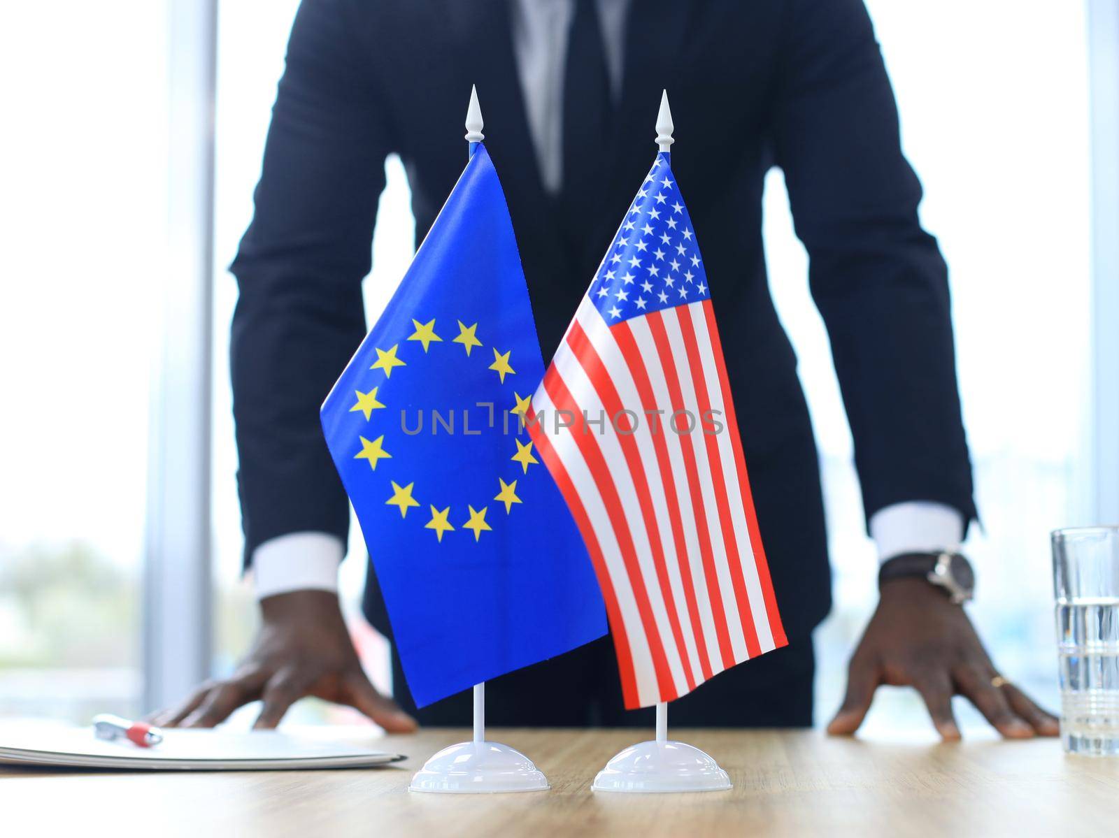 American flag and flag of European Union with businessman near by.