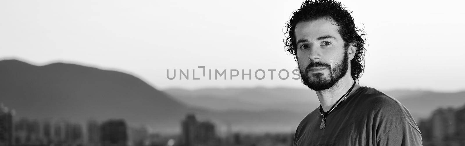 happy young man posing outdoor in urban enviroment with graffiti in background 