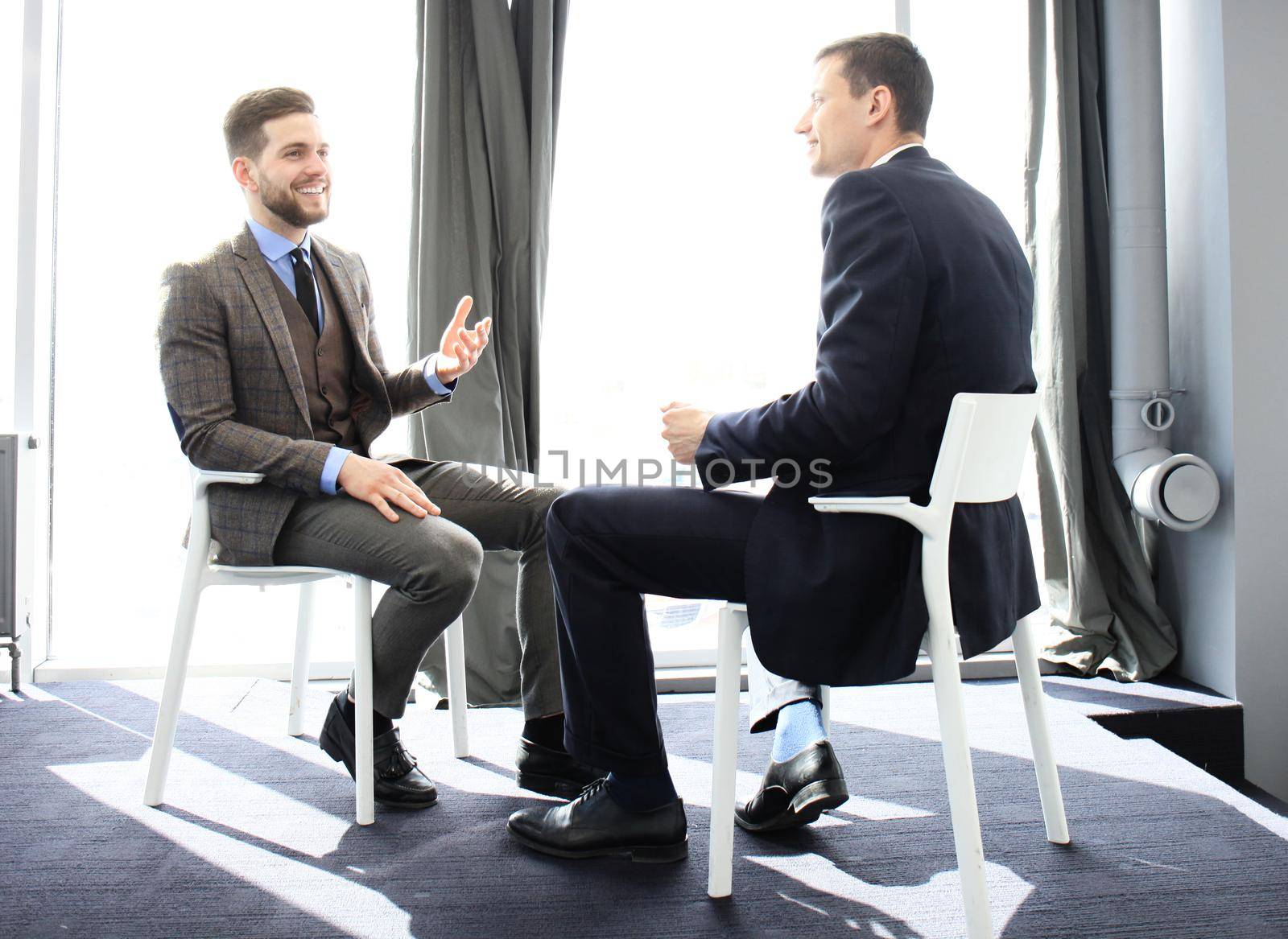 Two business colleagues at meeting in modern office interior by tsyhun