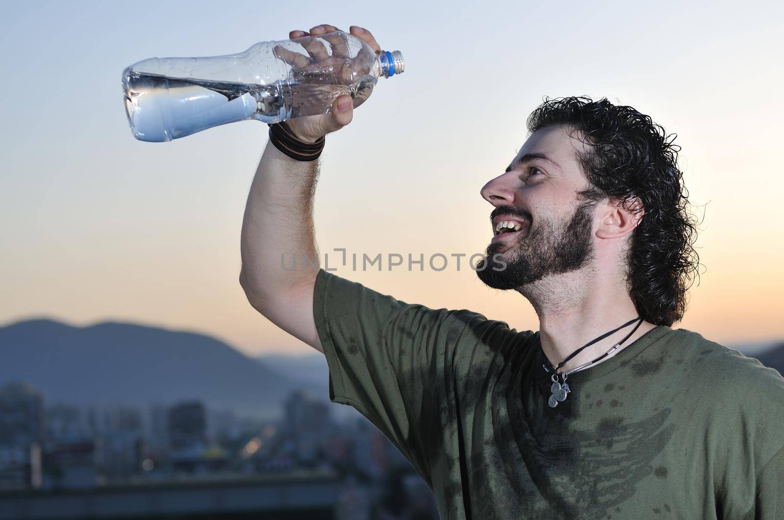 young man dring fresh water from bottle outdoor