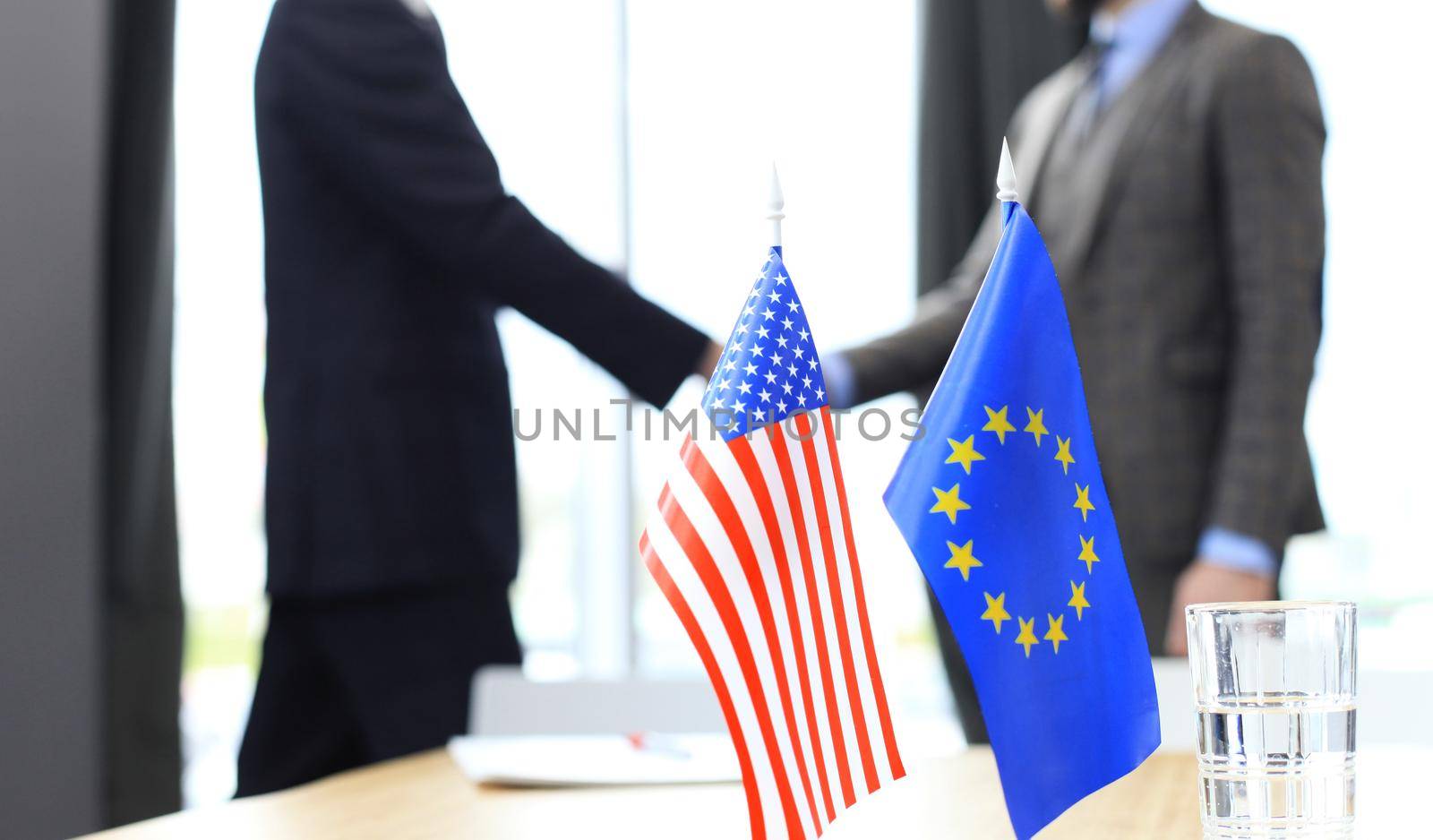 European Union and American leaders shaking hands on a deal agreement. by tsyhun