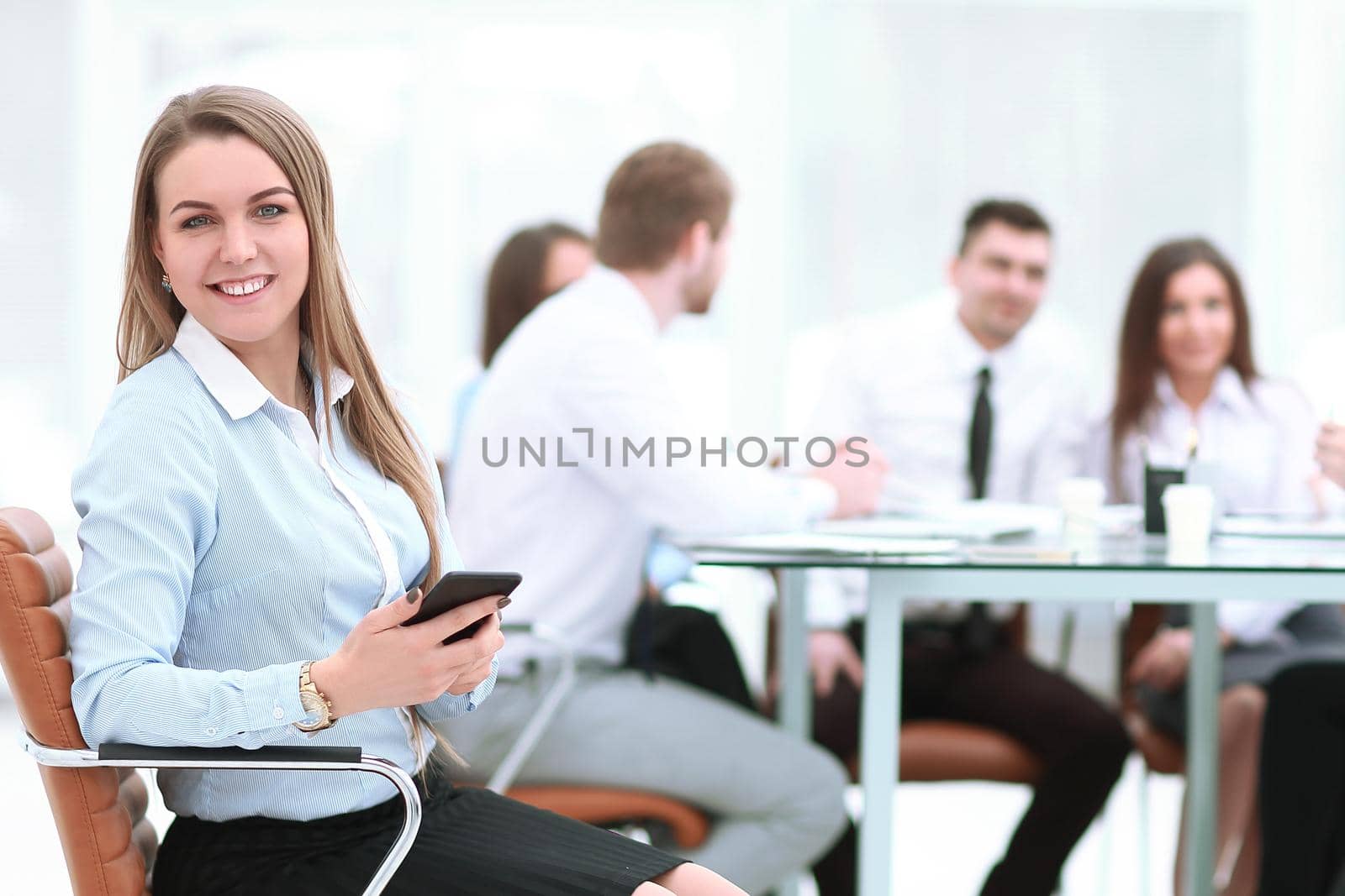 young employee with a smartphone on the background of business team.