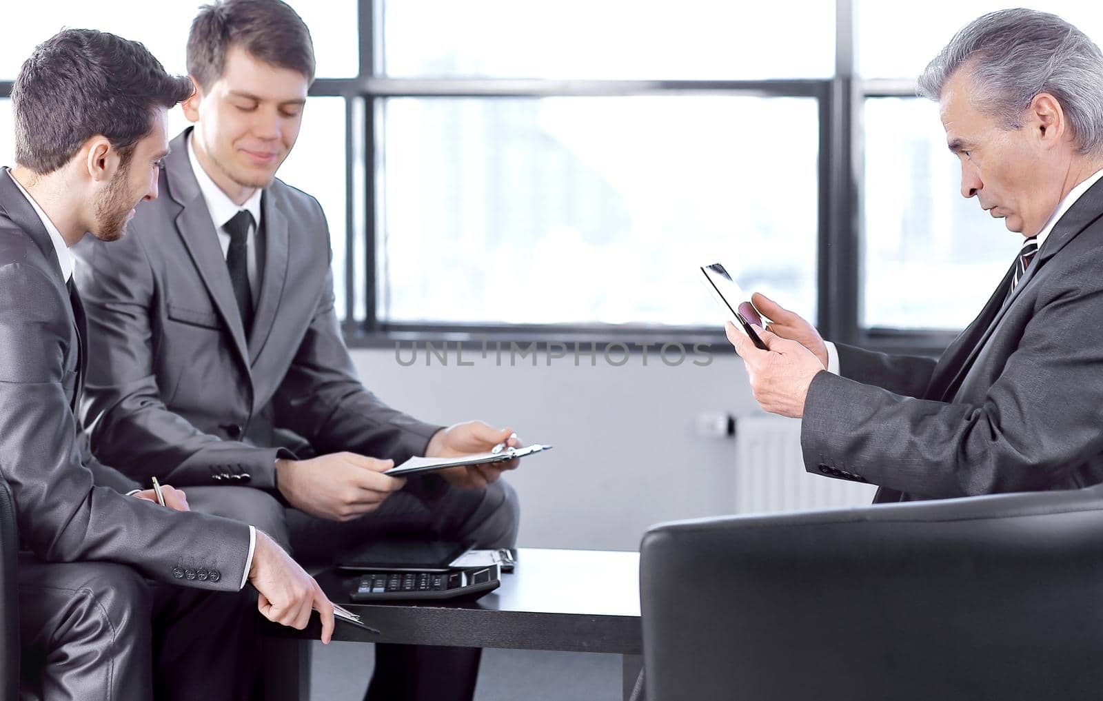 boss with a clipboard , sitting in an office.