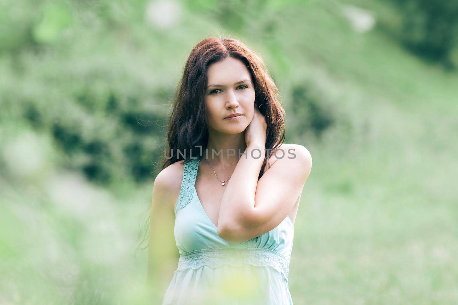 pensive young woman standing in summer Park. photo with copy space