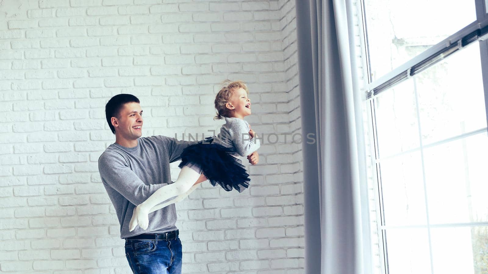 happy father playing with his baby daughter the bright living