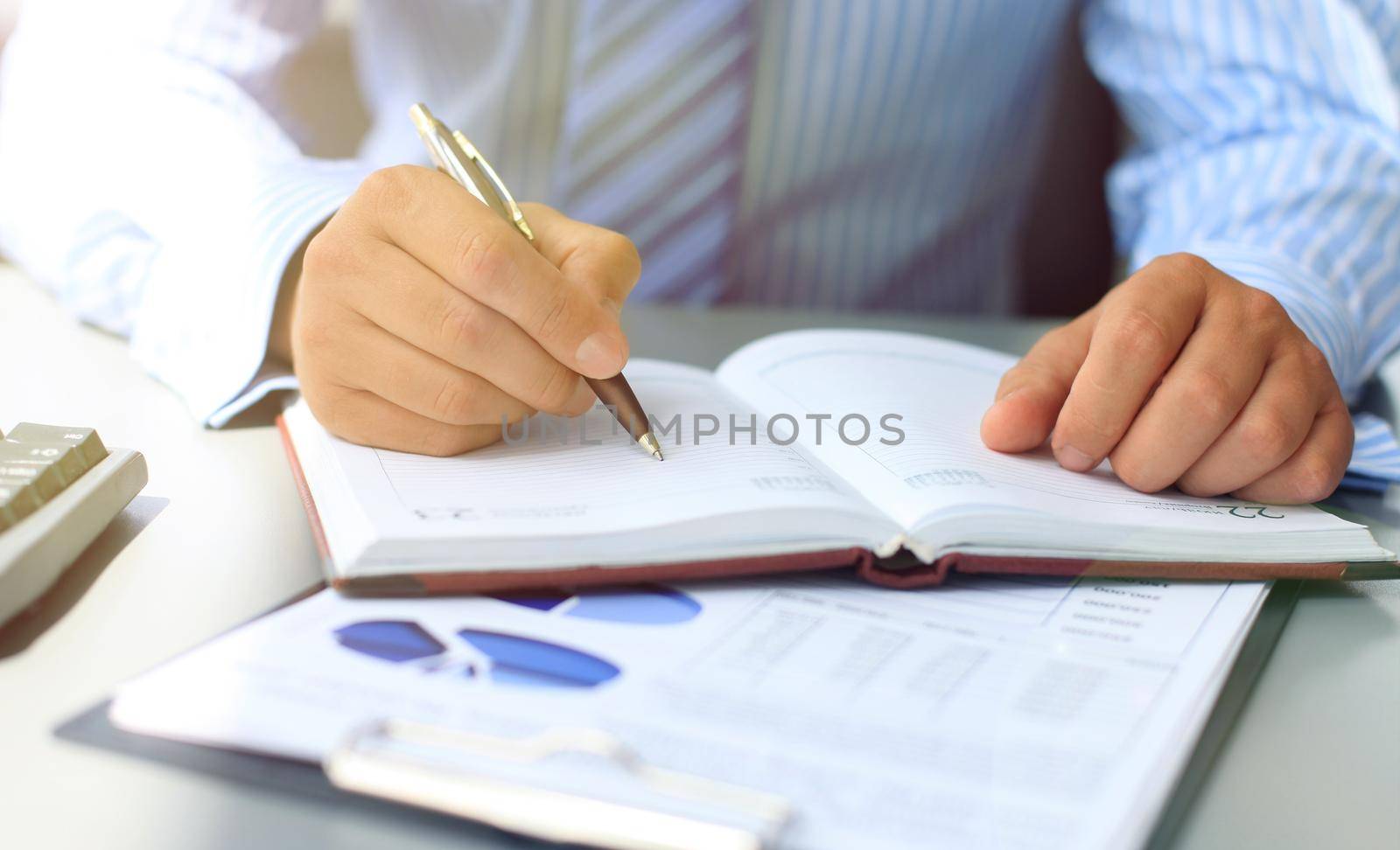 Businesswoman makes a note in notebook.