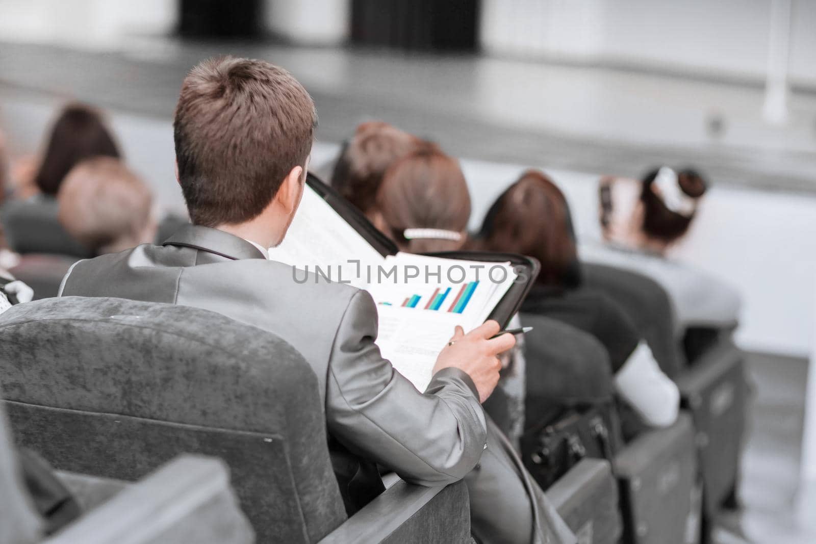 rear view. businessman sitting in the hall at a business presentation. business and education