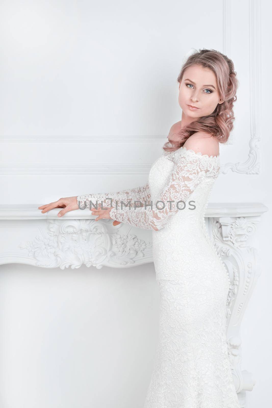 beautiful young woman in wedding dress standing in Bridal salon . holidays and events