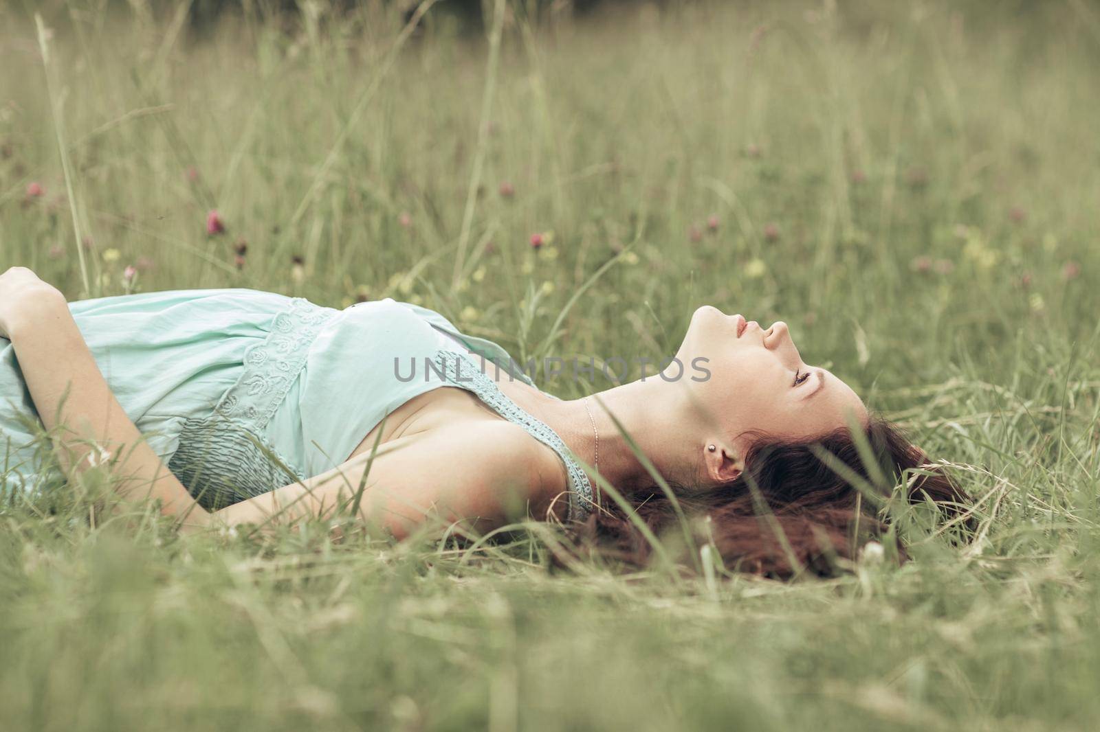 cute girl resting in a clearing on a hot summer day . photo with copy space