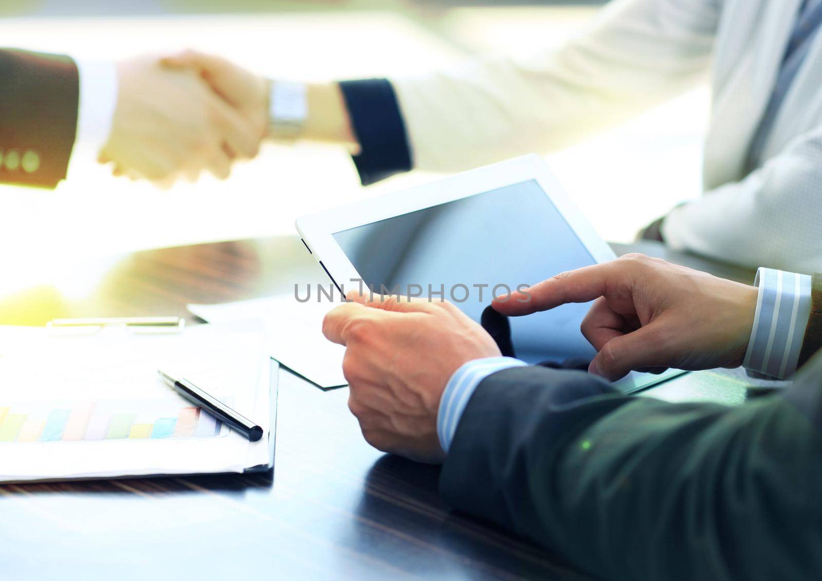businessman hands touching digital tablet empty screen copy space, handshake during meeting.