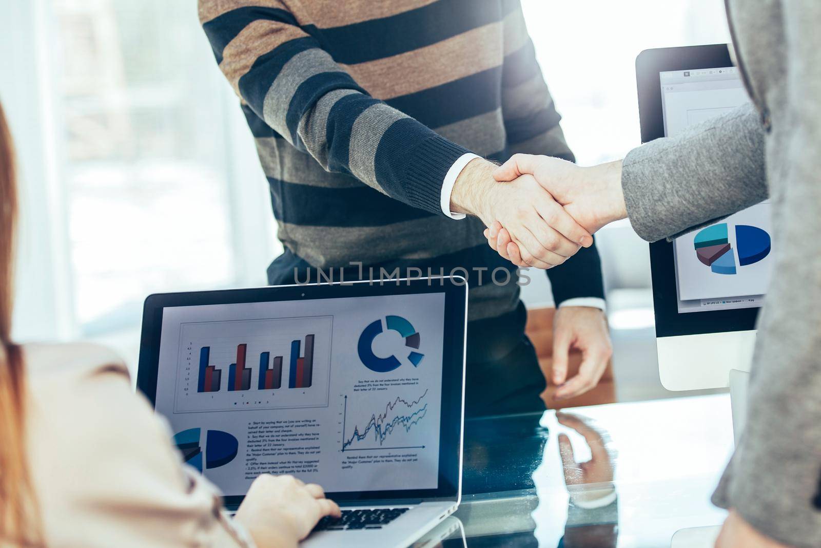 handshake between the client and the Manager of the company near the workplace in the modern office.