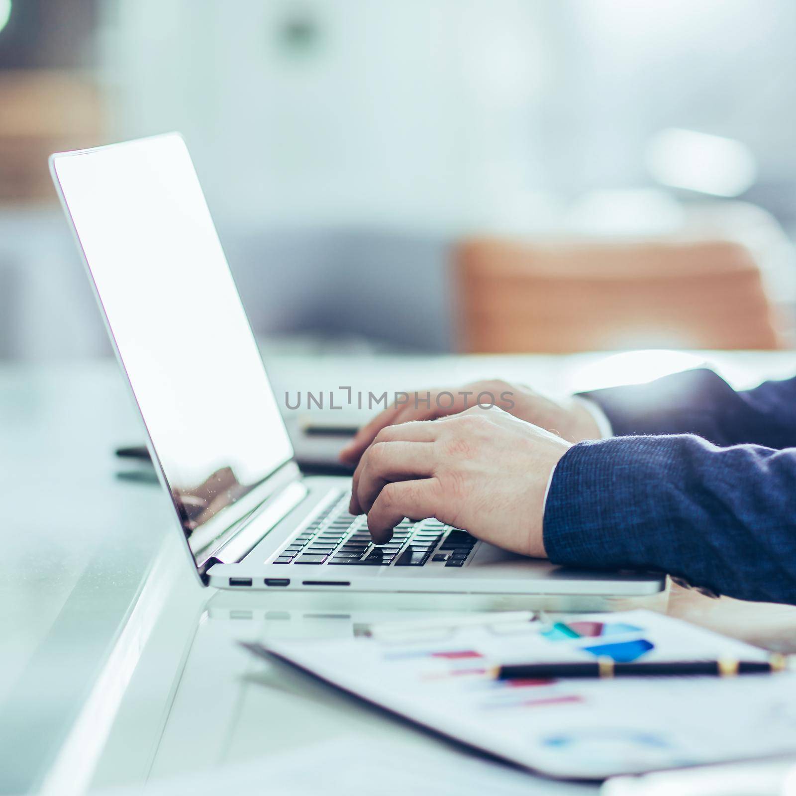 financial managers working on laptop with financial data at the workplace in a modern office by SmartPhotoLab