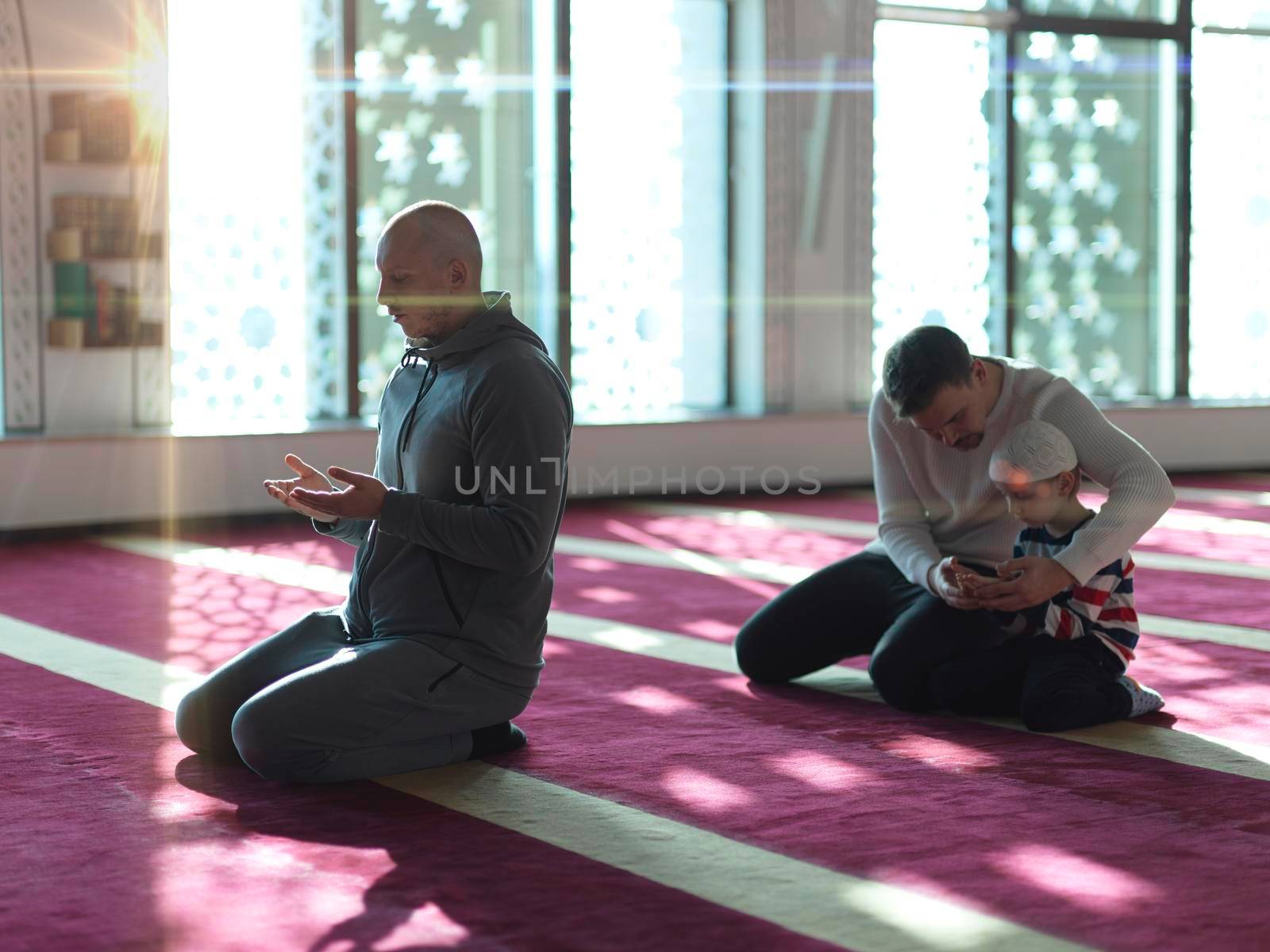 muslim prayer father and son in mosque praying and reading holly book quran together islamic education concept