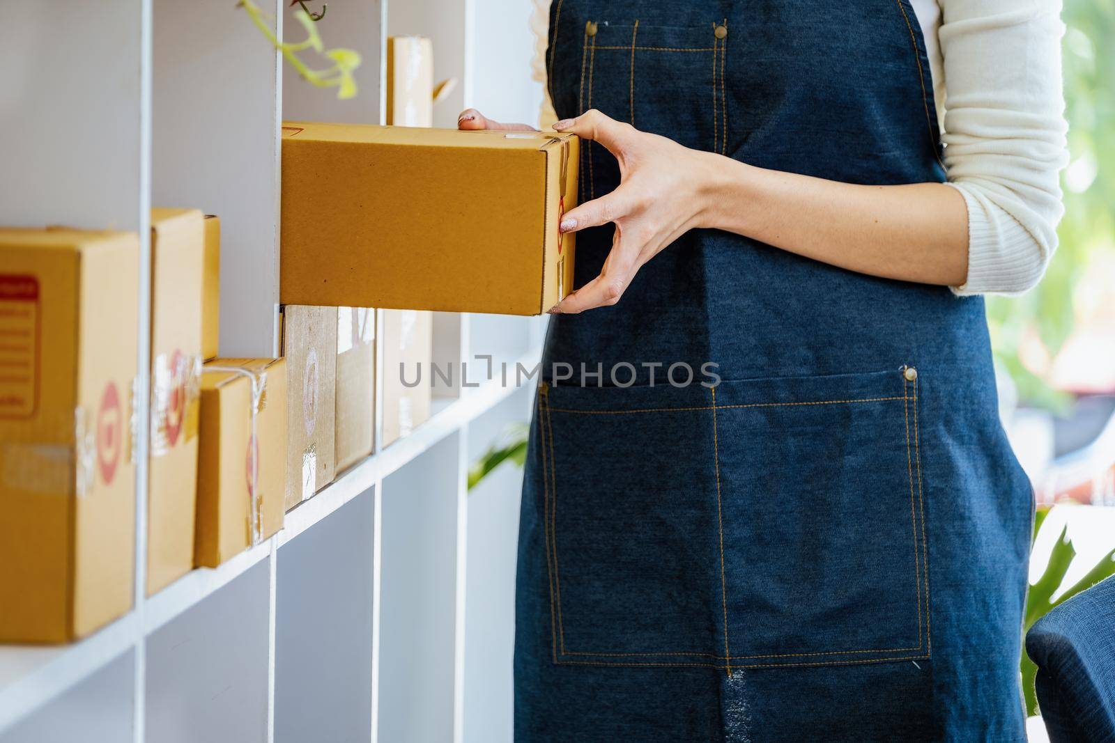 Work from home. happy women selling products online Startup small business owners are picking up parcel boxes to pack customer orders and prepare them for postage
