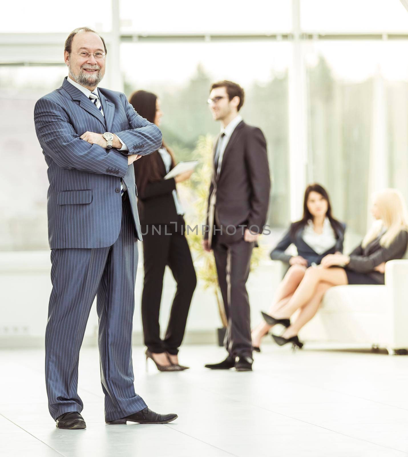 photo in full growth, a businessman on the background of business team .the photo has a empty space for your text
