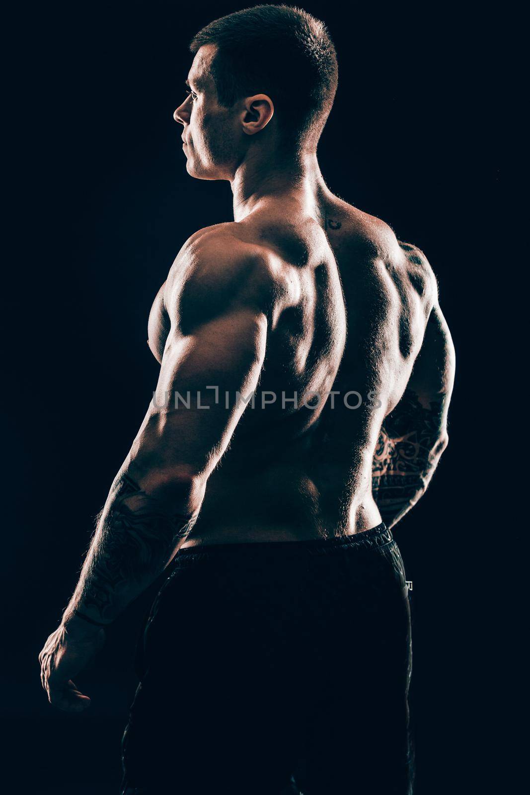 rear view.handsome male bodybuilder .isolated on black background