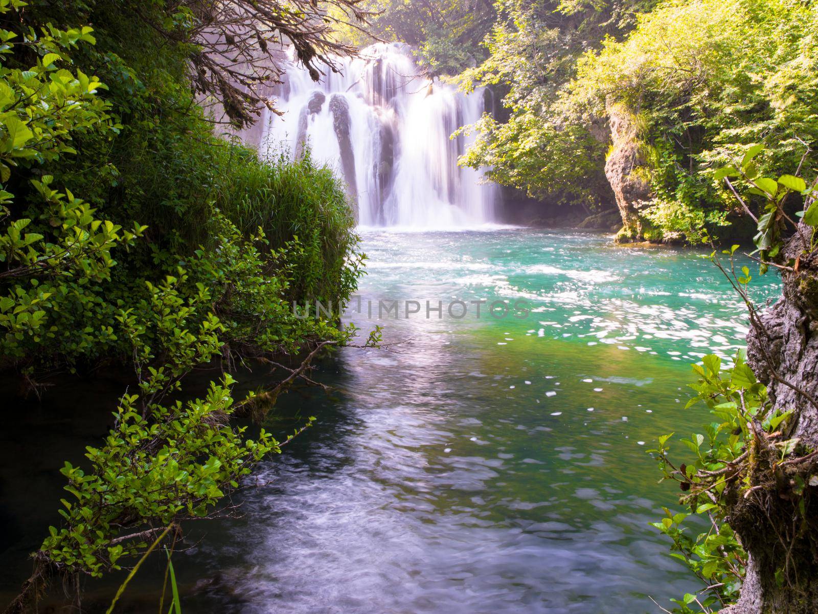 Amazing nature landscape, beautiful waterfall with sunlight in deep summer forest