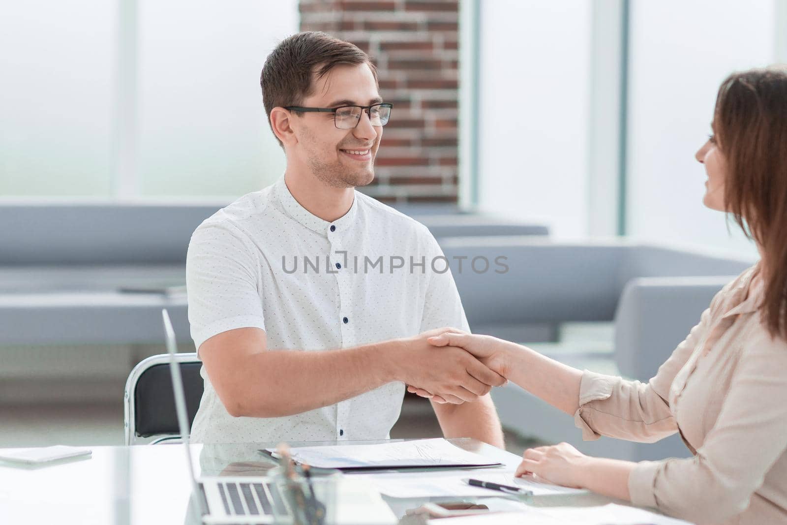 handshake of a businessman and businesswoman sitting at office Desk. concept of cooperation