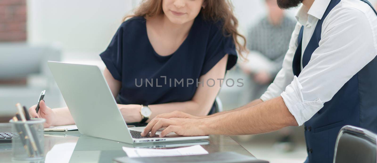 employees using a laptop to work with financial data by SmartPhotoLab