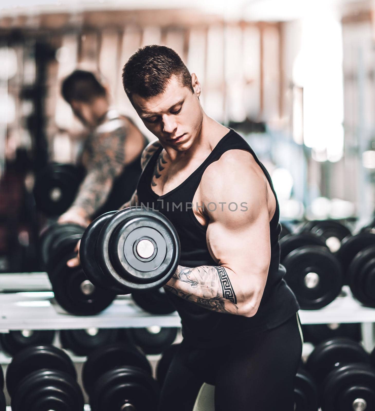 purposeful bodybuilder performs exercises with dumbbells .photo with copy space
