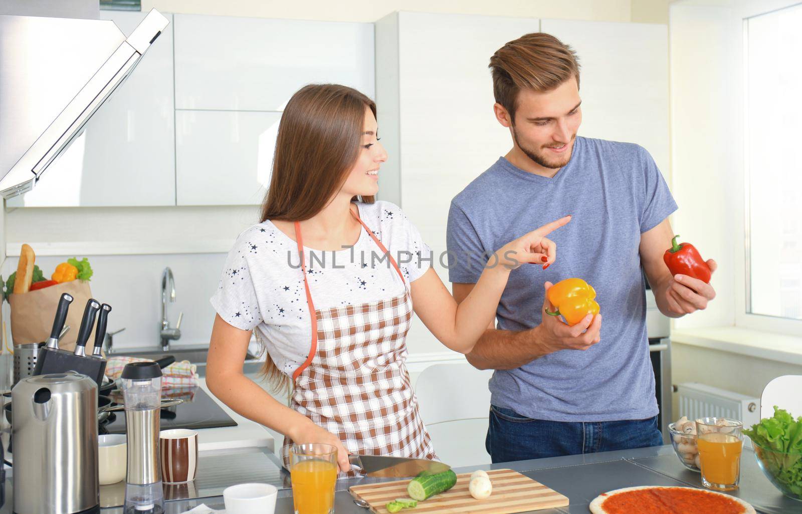 Portrait of happy young couple cooking together in the kitchen at home. by tsyhun