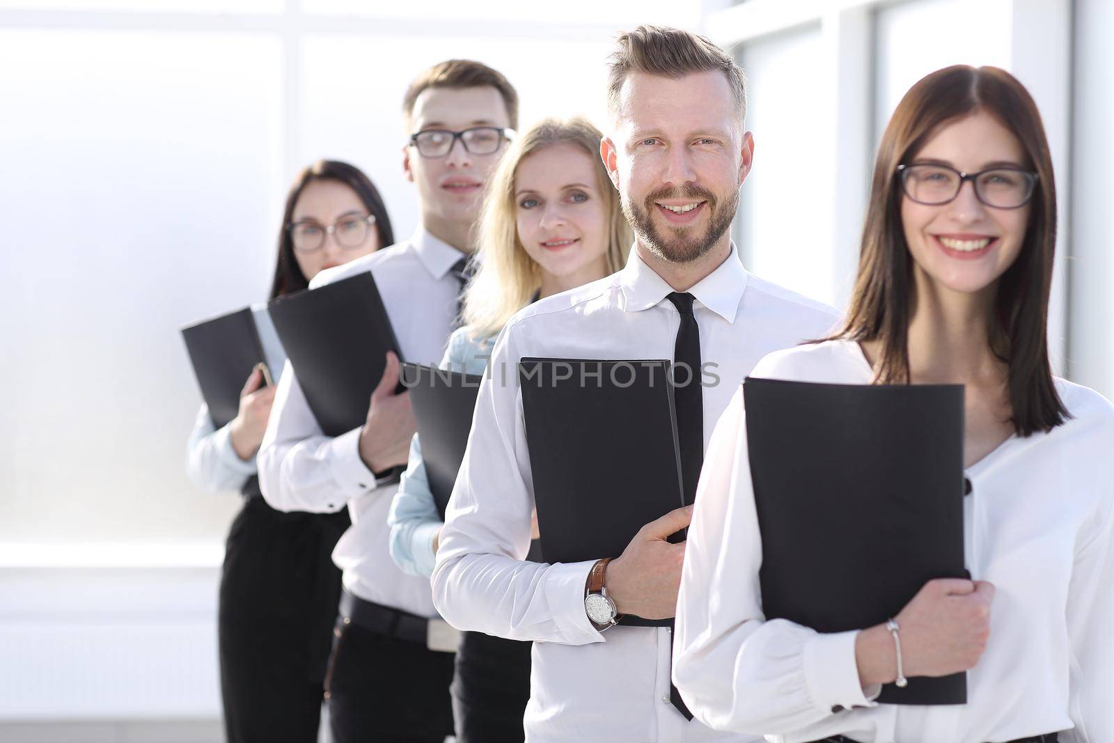 close up. employees with file folders standing in line. business and education