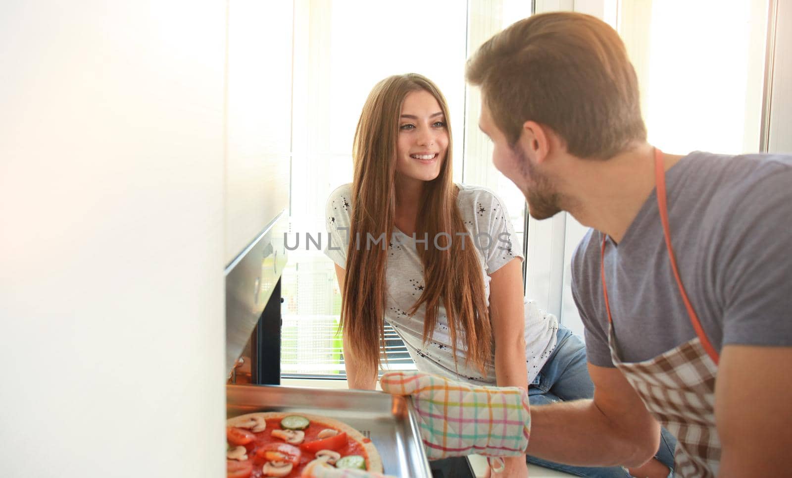 Young couple making pizza in kitchen together