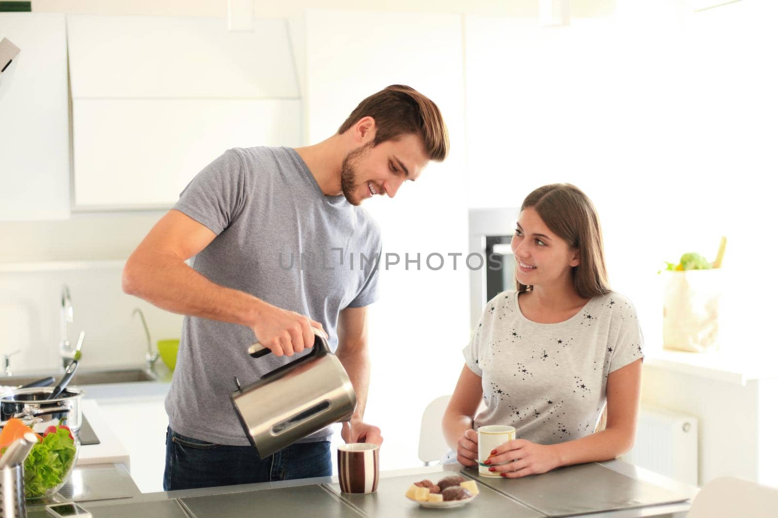 Cute young couple drinking coffee in kitchen by tsyhun