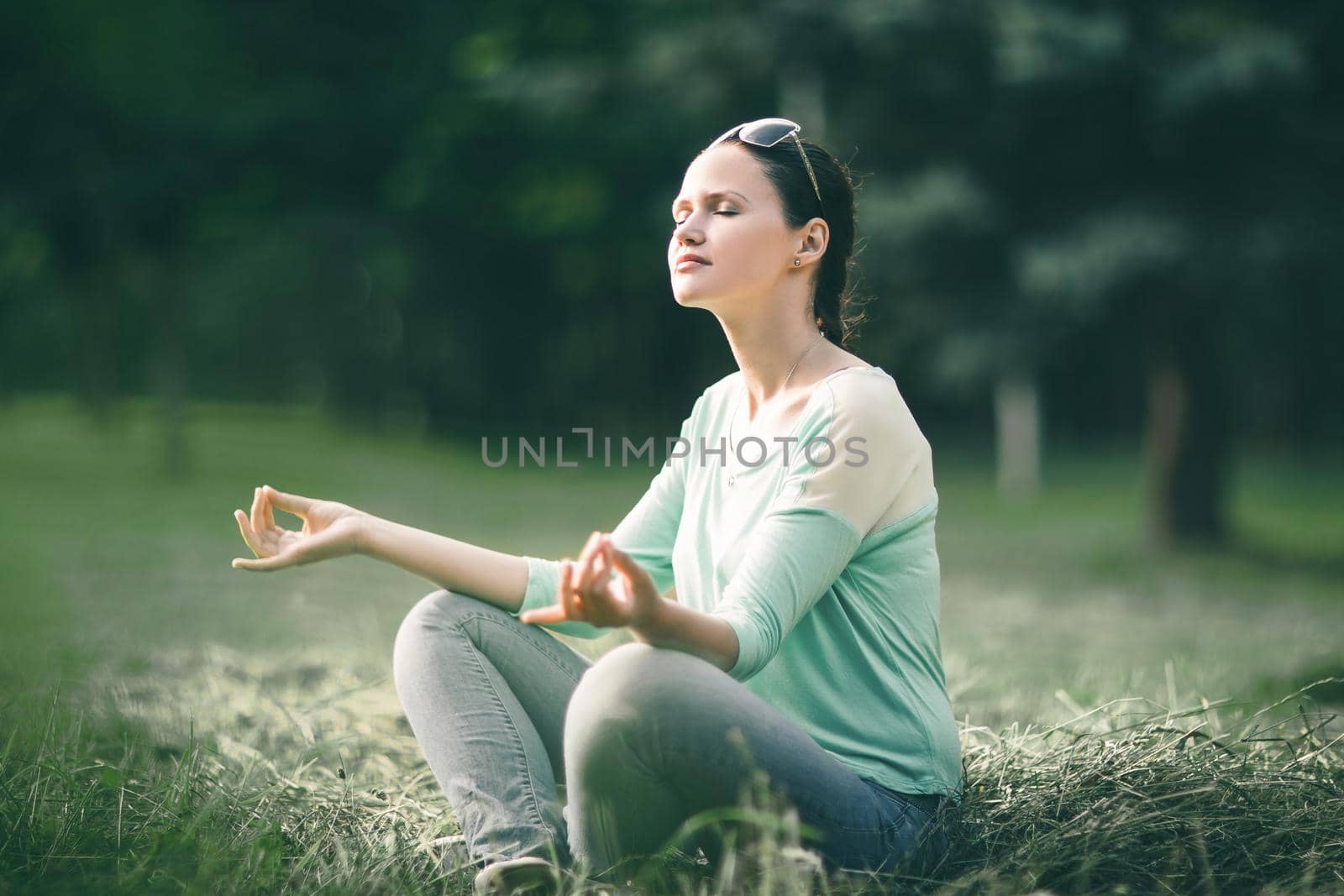 beautiful young woman meditating in Lotus position in morning Park. photo with copy space