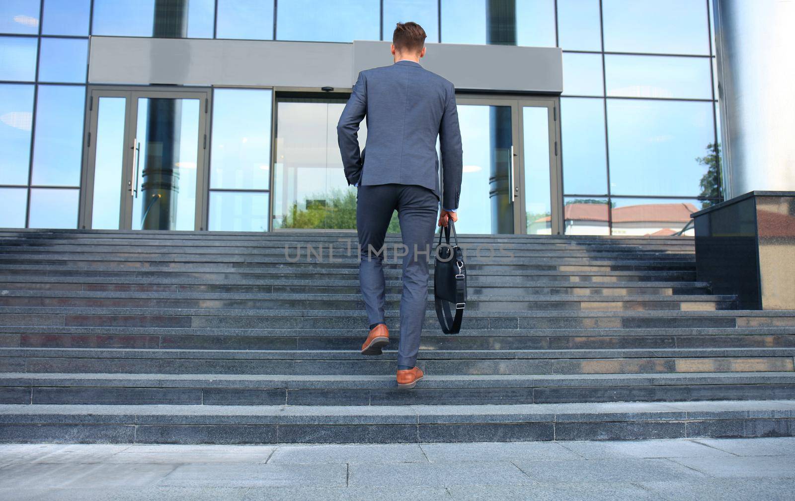 Business executive with briefcase going up the stairs. by tsyhun