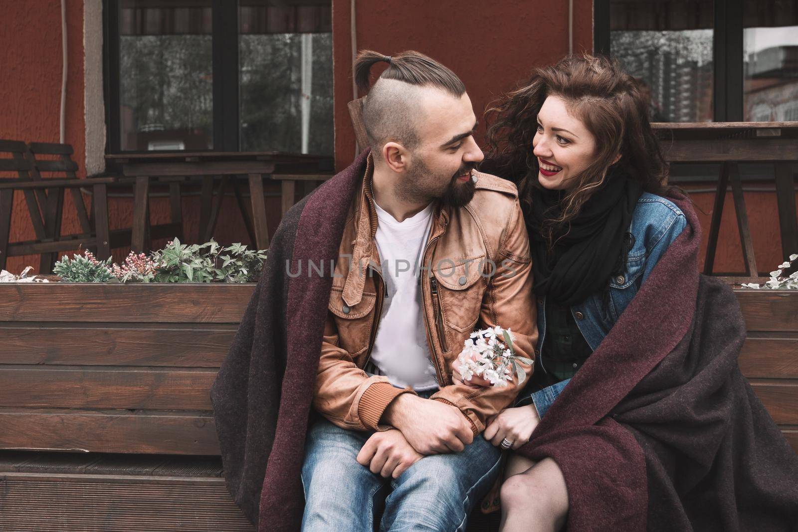 young couple sitting on a bench in the old city street. love story