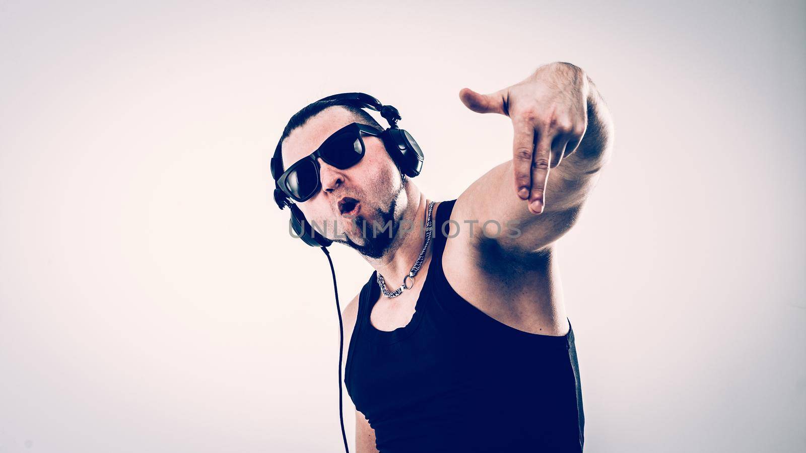 DJ - rapper in headphones takes the rap and break dancing dance on a light background.the photo has a empty space for your text