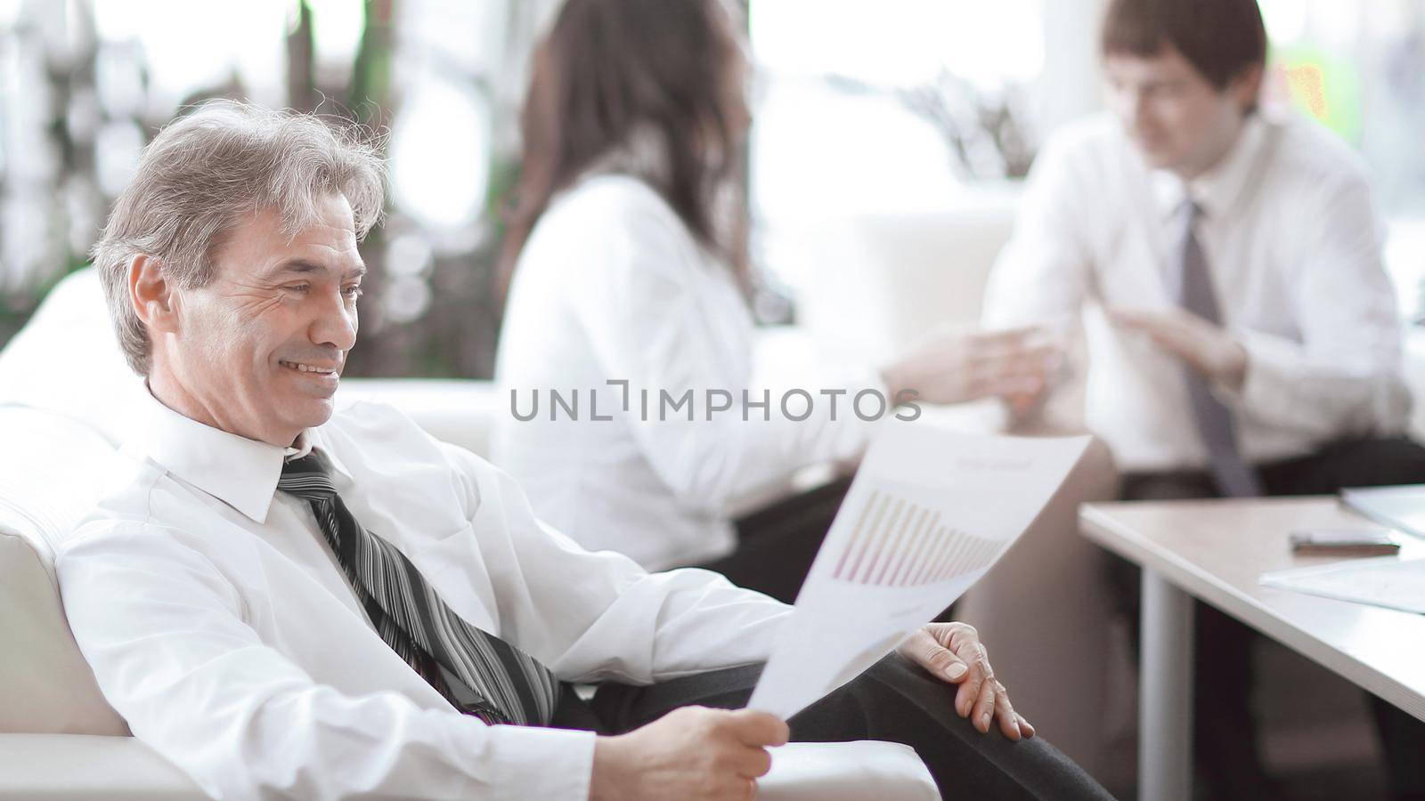 businessman pondering a document sitting in a modern office.photo with copy space