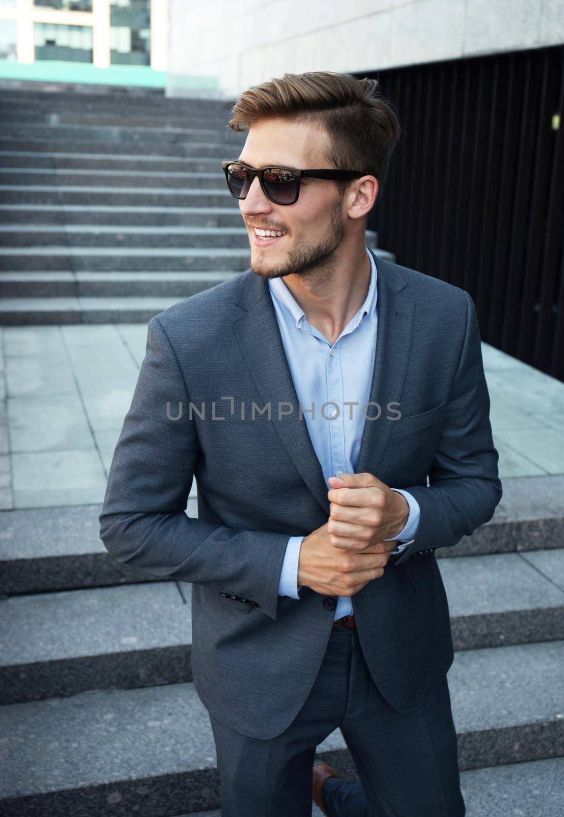 handsome stylish man in elegant suit and sunglasses in the street.