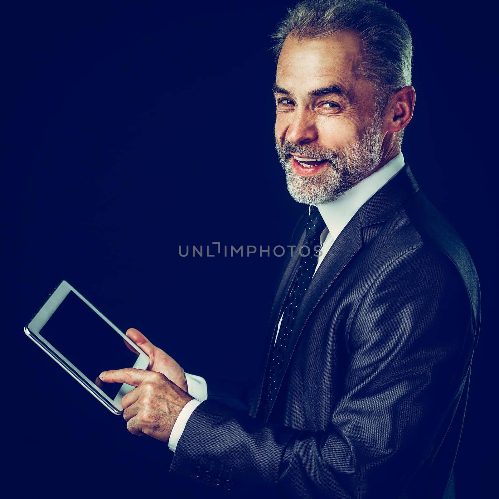 experienced businessman with digital tablet on black background. by SmartPhotoLab