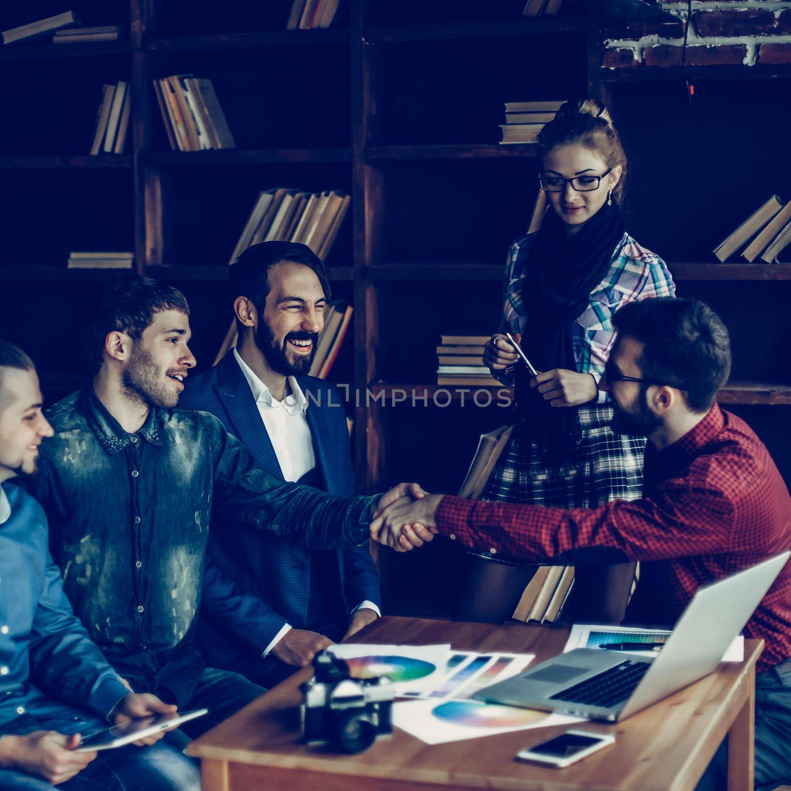 advertising Manager with a handshake greets the customer in a modern office