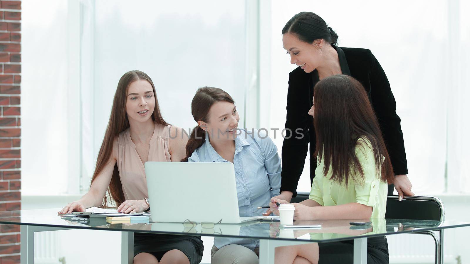 smiling group of women behind a Desk in the office.