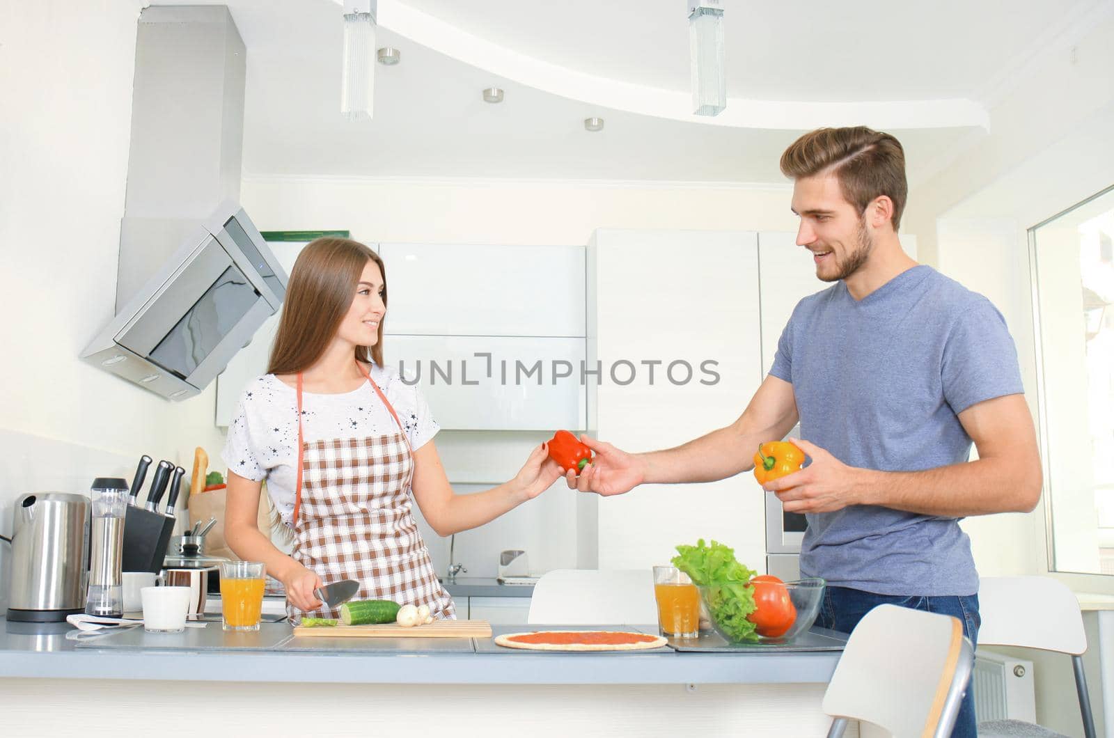 Young couple making pizza in kitchen together