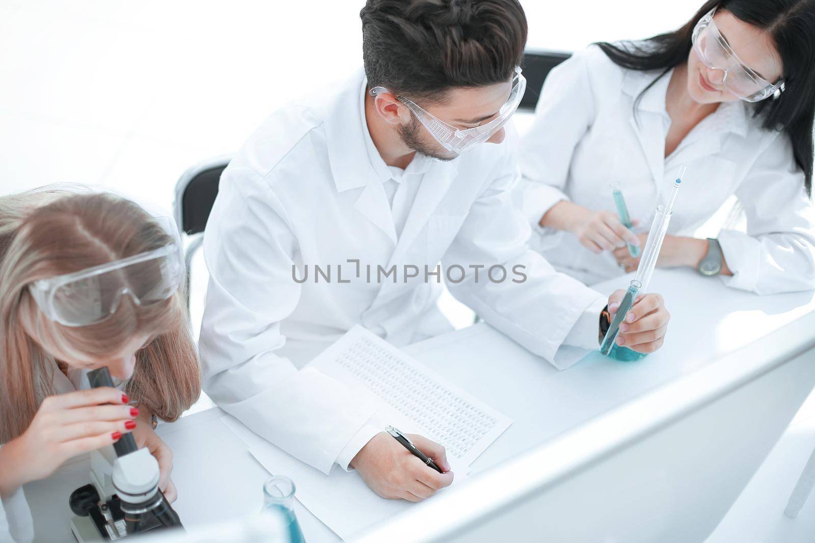 close up. a group of scientists conduct research and make entries in the journal. science and health