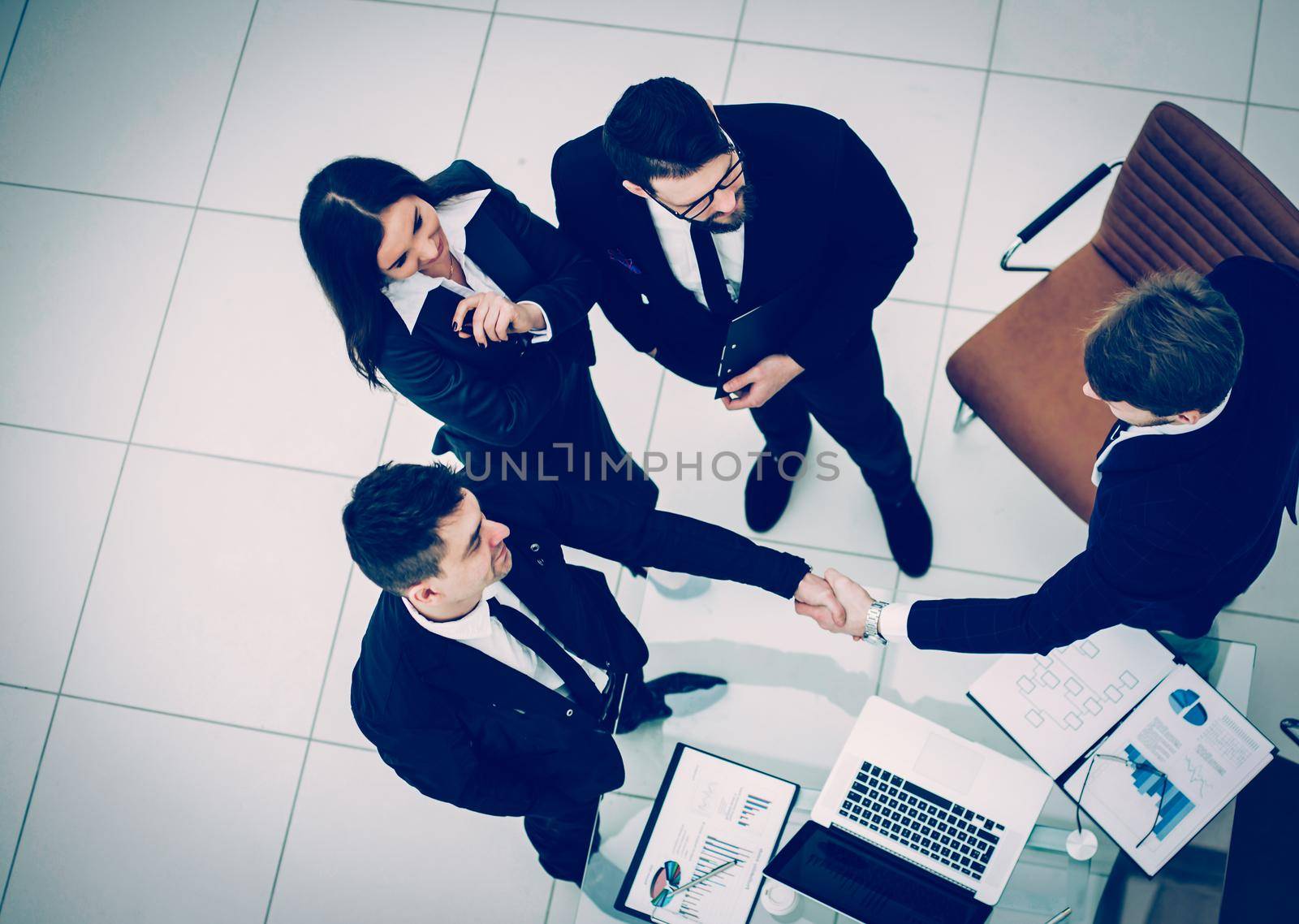 top view - reliable handshake business partners after the discussion of the financial contract in the office.the photo has a empty space for your text.
