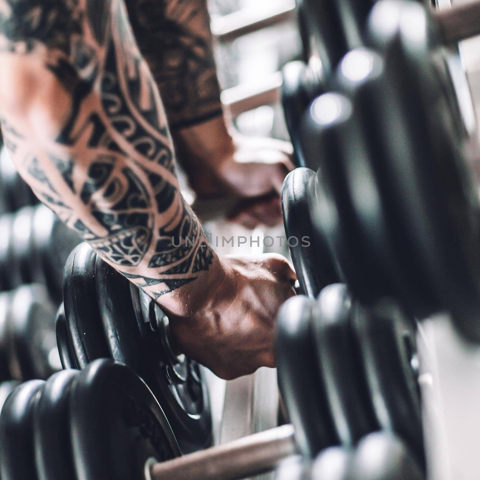 close up. muscular man lifting a dumbbell from the rack