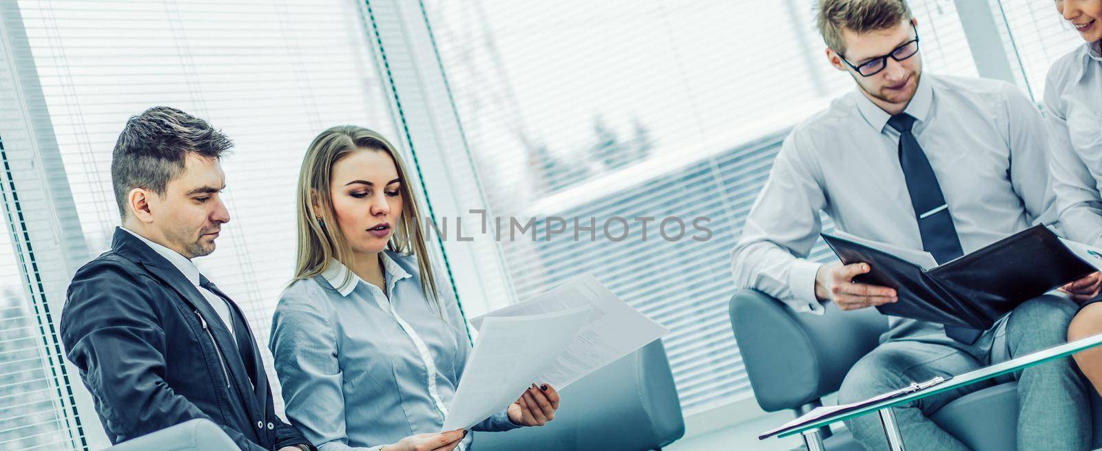 employees of the company with documents sitting in the reception room before the conference.the photo has a empty space for your text