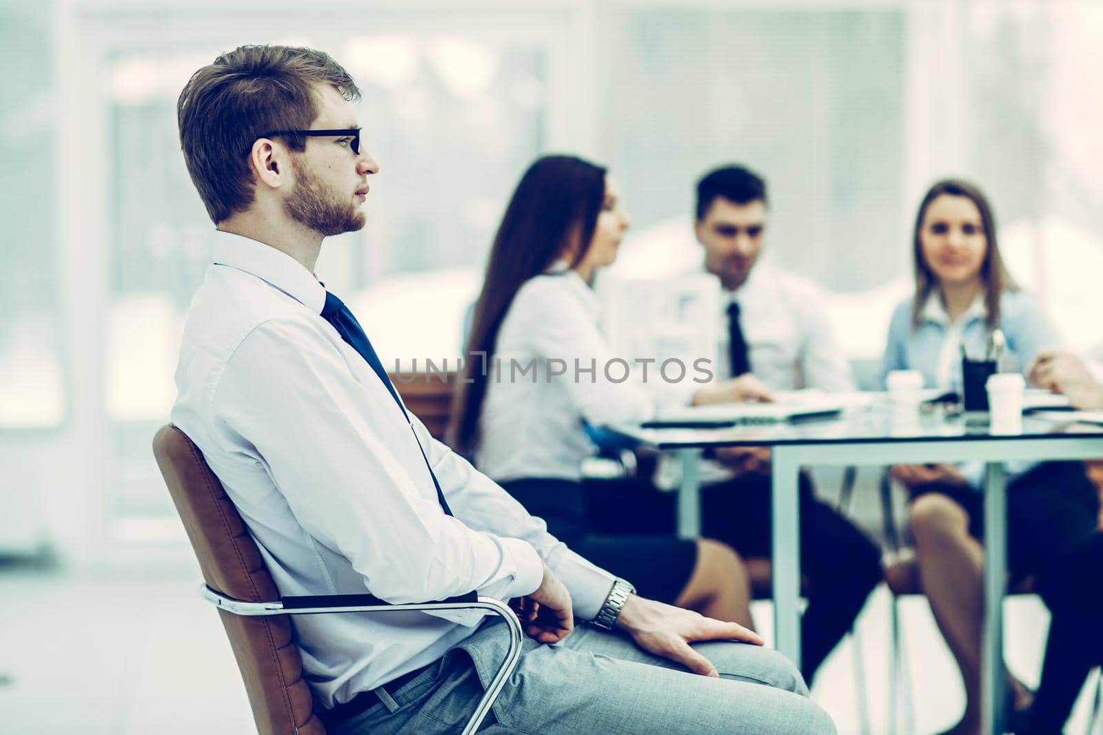 successful Manager sitting in an office chair in the background of the business team and the workplace