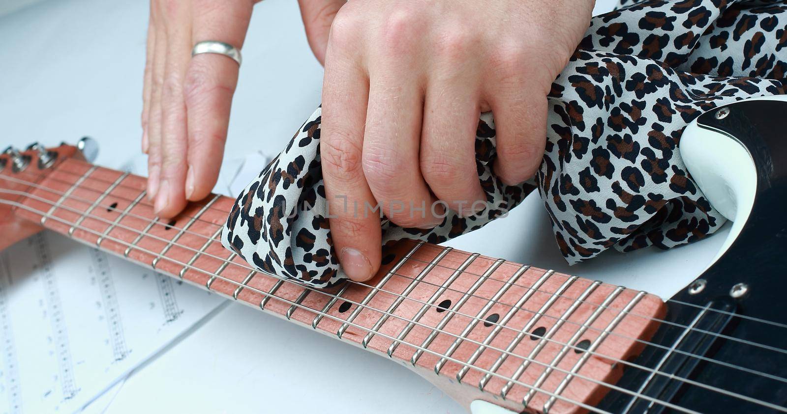 closeup.rock guitarist,wiping the neck of the guitar .photo with copy space