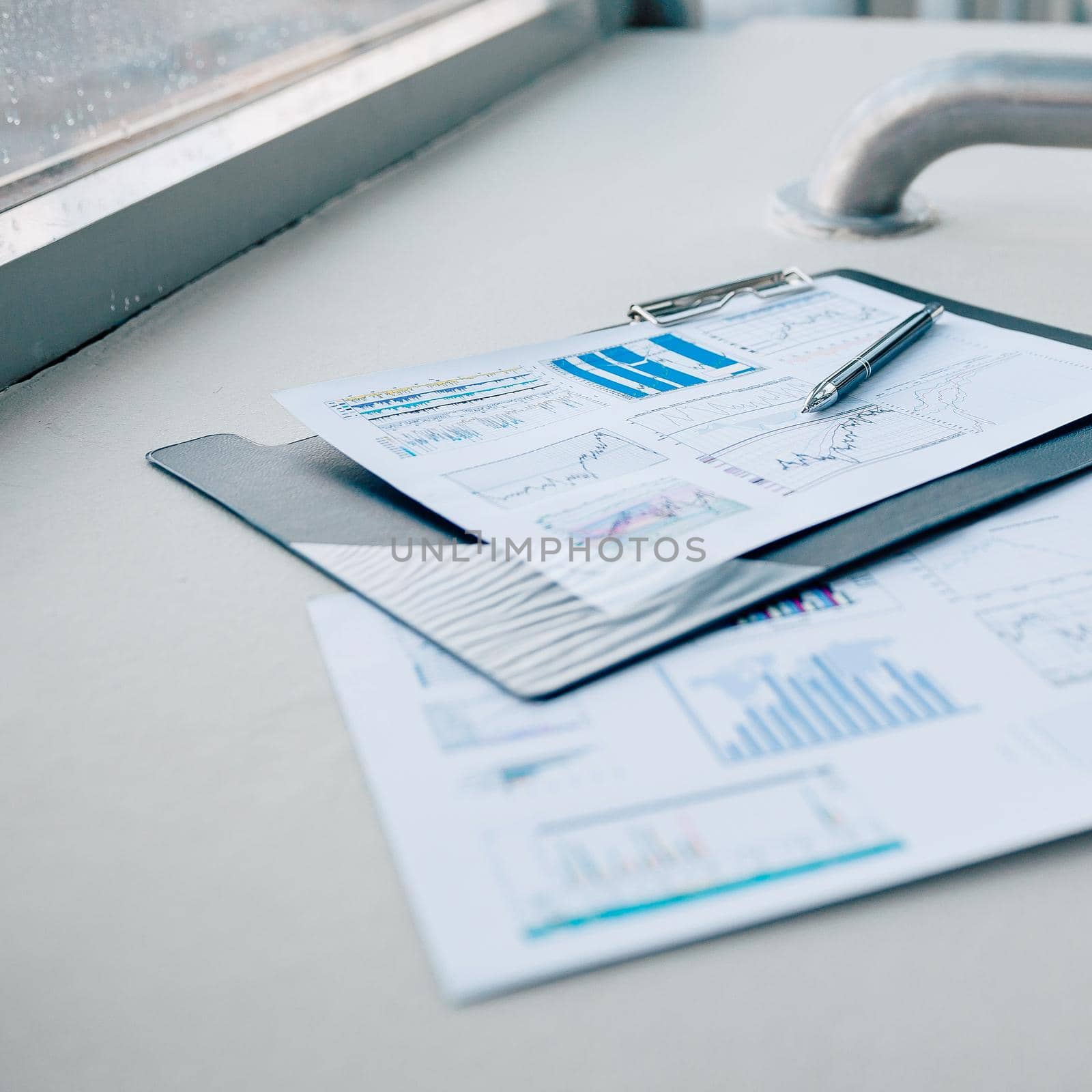 pen and financial documents on the desktop in the office by SmartPhotoLab