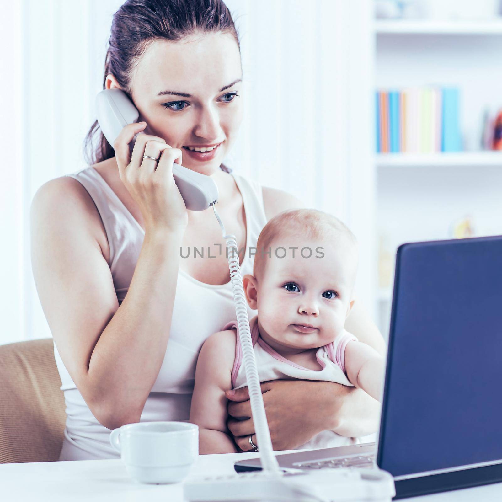 young mother and baby using laptop to communicate with grandma via Skype,at home in the nursery