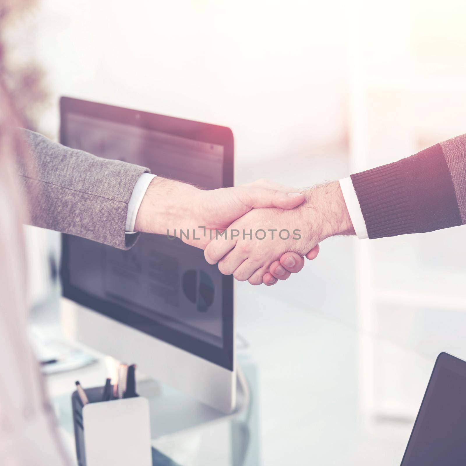 handshake between the client and the Manager of the company near the workplace in the modern office.