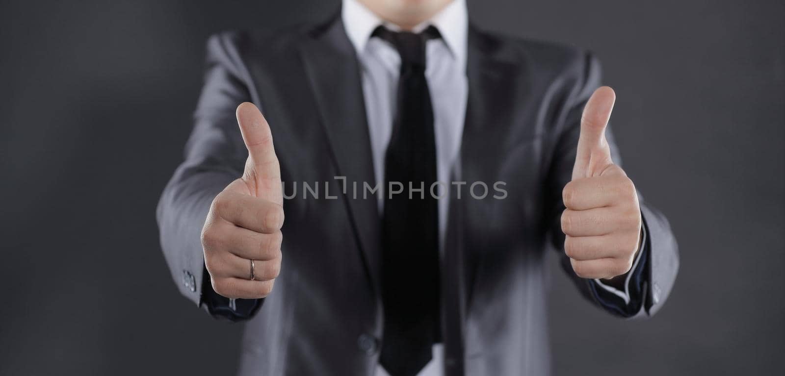 close up.modern businessman showing thumbs up.isolated on black.